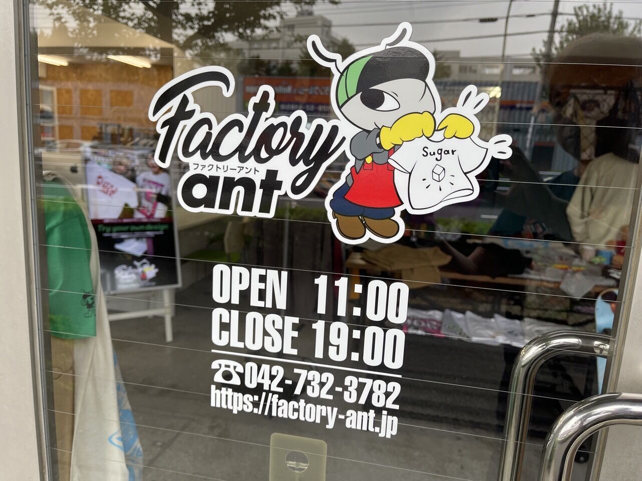 Factory antの入り口に貼られたアント君のステッカー。分かりやすく営業時間、サイトのアドレスが入っている